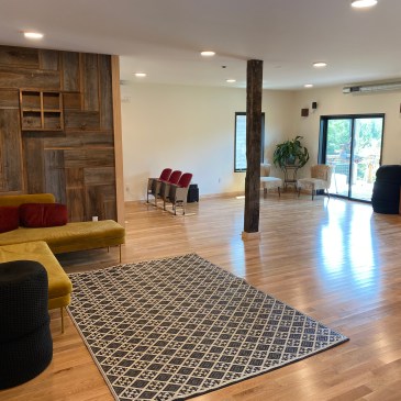 a large room with rug and minimal furniture